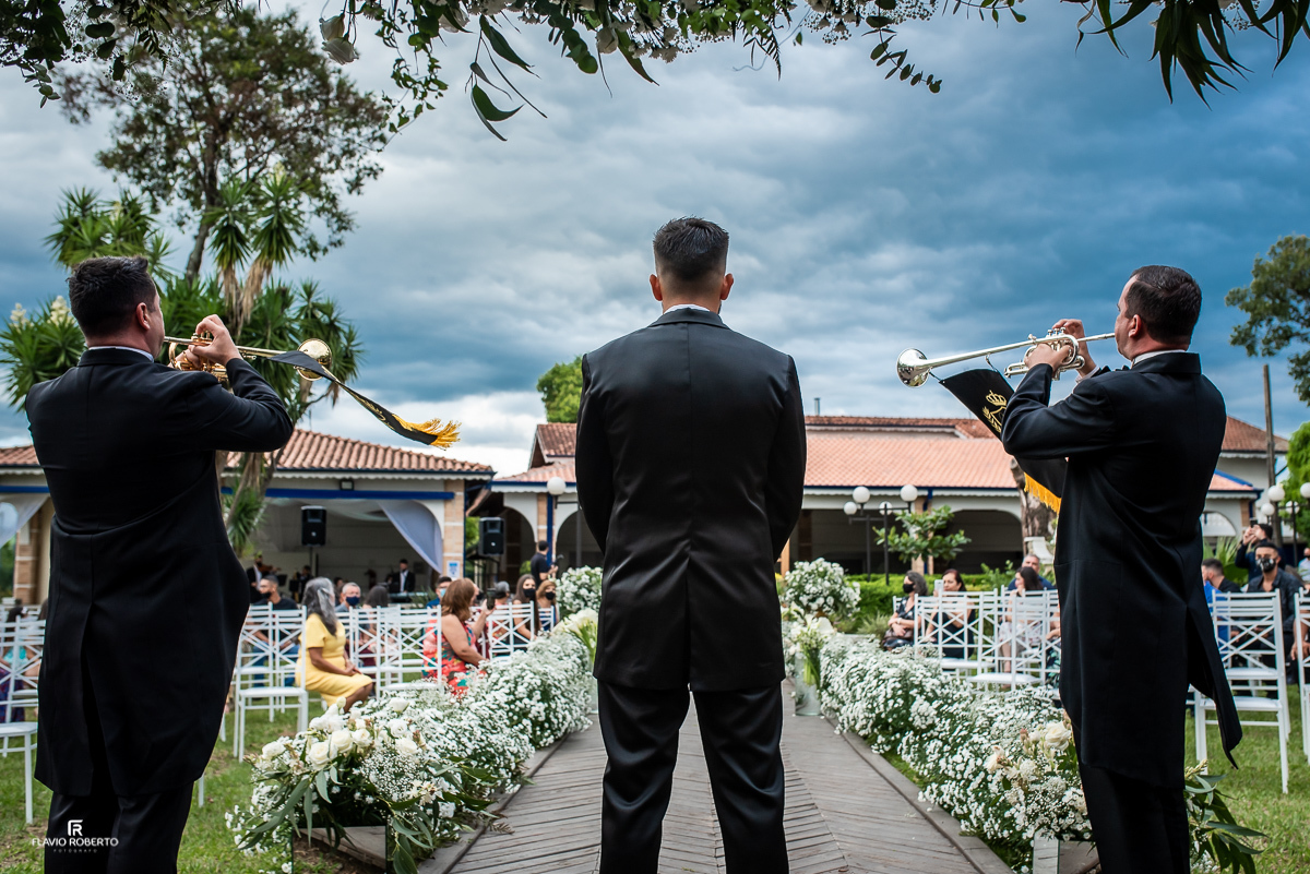 Noivo entre os músicos tocando trompete esperando a Noiva entrar durante Casamento na Chácara Santa Rita em Lorena -SP