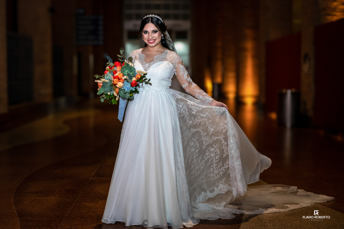 Noiva com vestido rendado segurando buquê colorido durante ensaio de casamento no Santuário Nacional de Aparecida do Norte