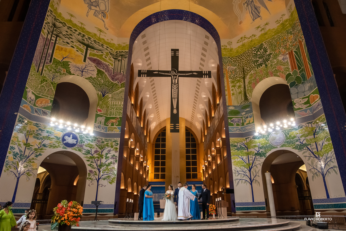 Vista ampla do altar do Santuário Nacional de Aparecida com noivos e padrinhos durante cerimônia de casamento religioso