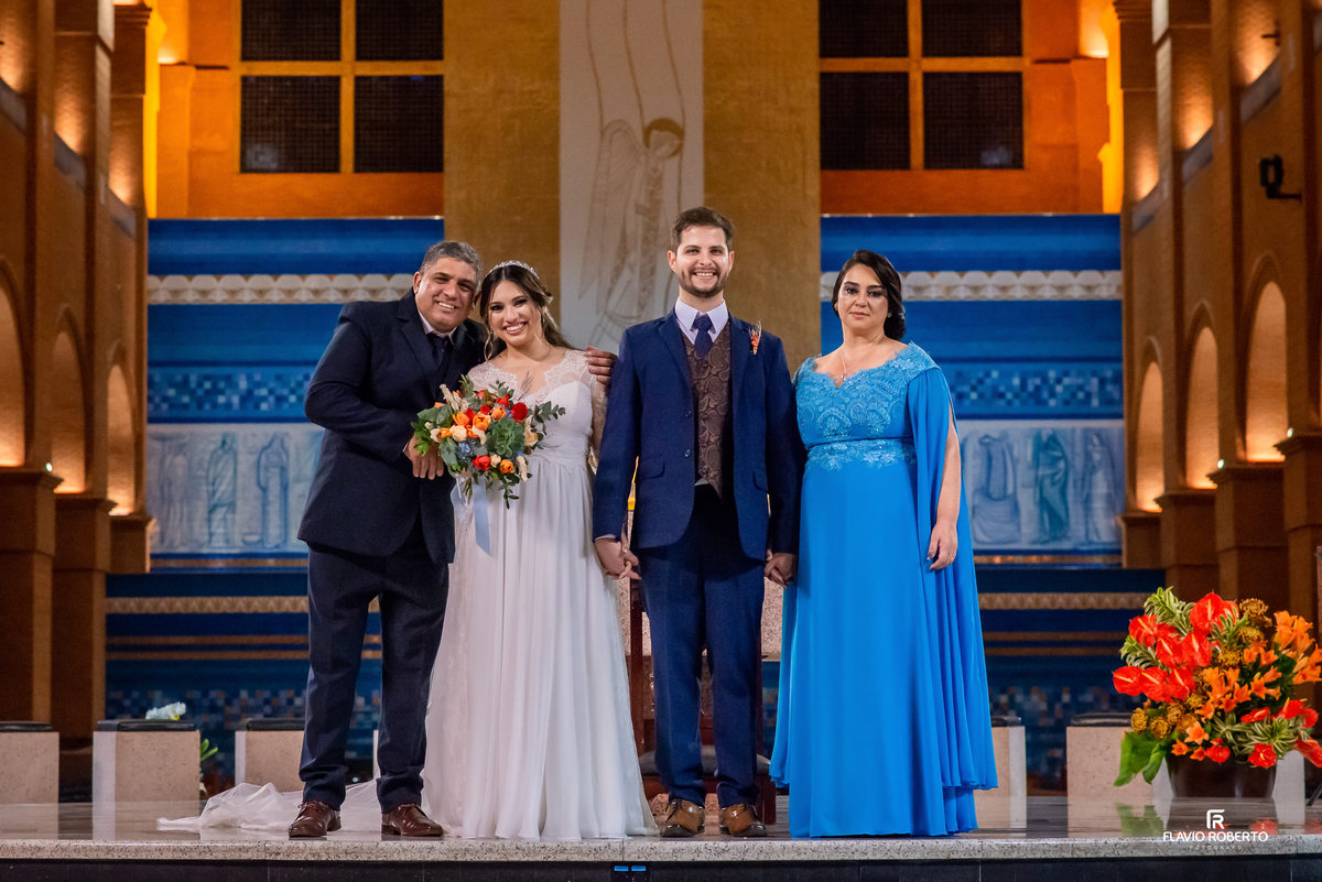 Noivos posando com os pais no altar do Santuário Nacional de Aparecida após a cerimônia de casamento