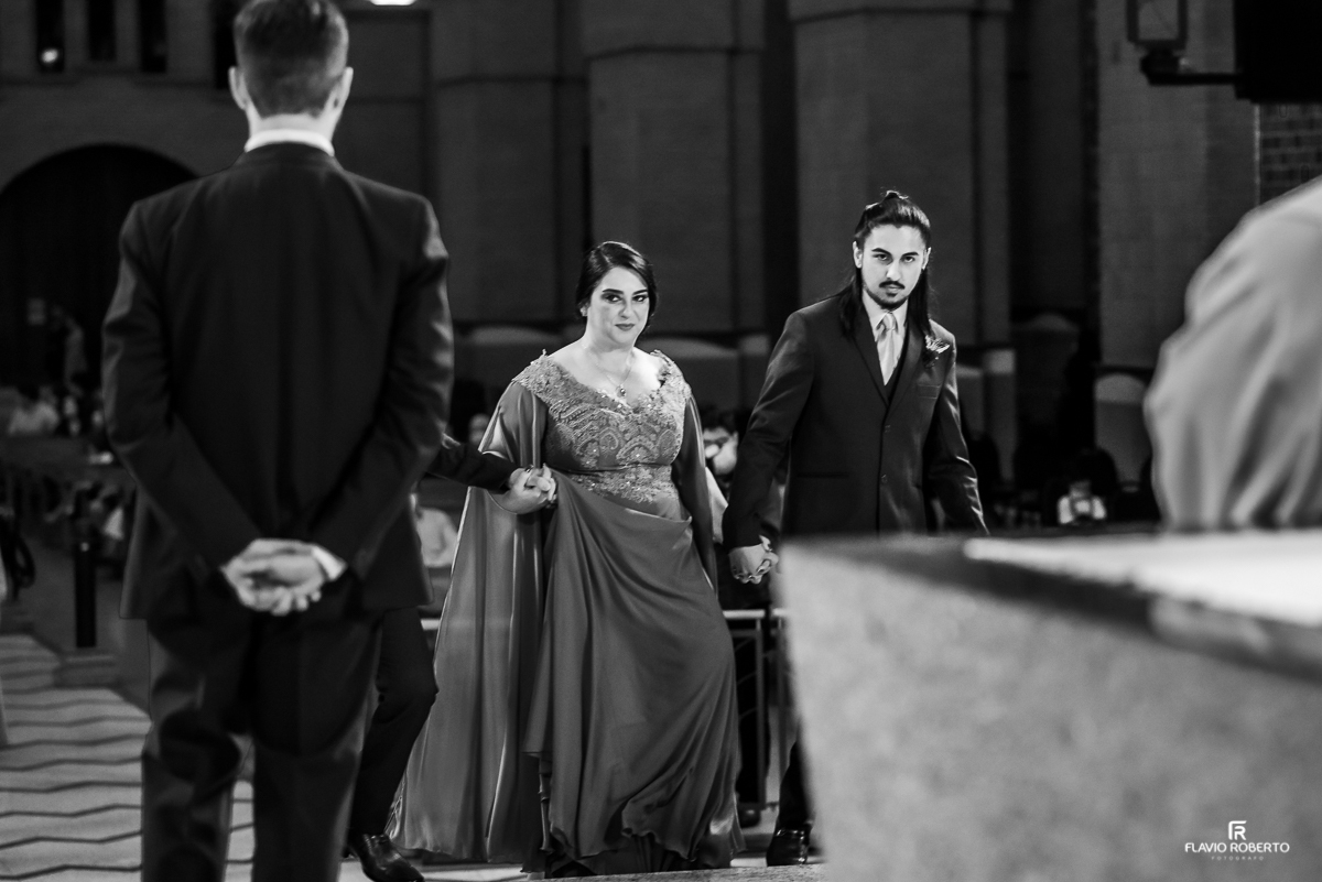 Mae da Noiva chegando no altar olhando para seu genro.