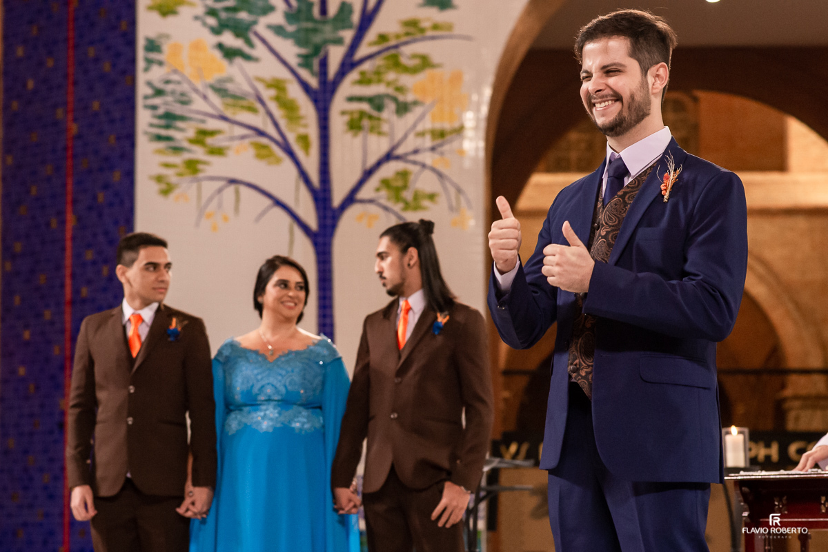 Noivo, sogra e cunhados rindo no altar durante casamento no Santuário Nacional de Aparecida-SP.