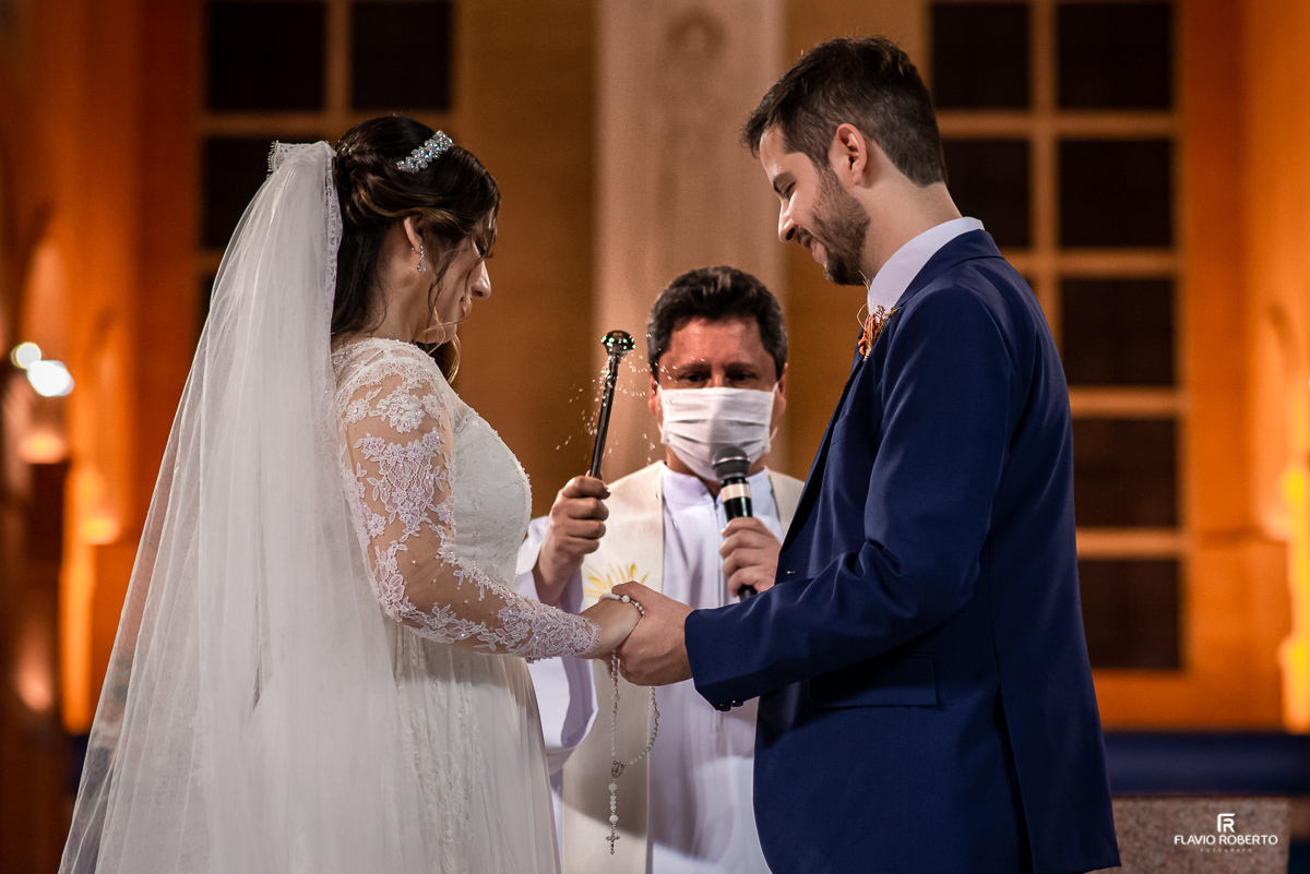 Padre abençoando alianças dos noivos durante Casamento no Santuário Nacional de Aparecida-SP.