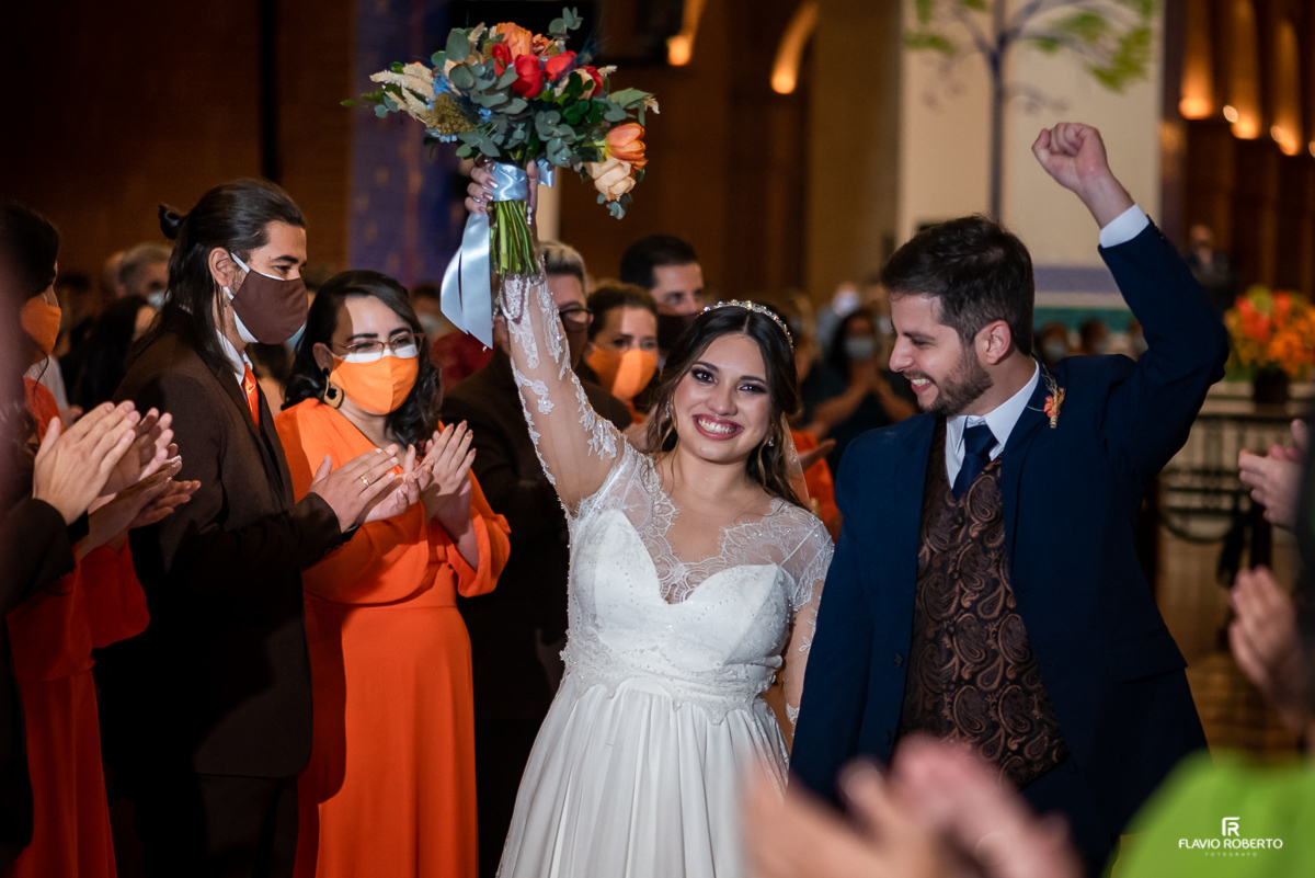 Noivos celebrando seu Matrimonio passando entre os padrinhos no Santuário de Aparecida.