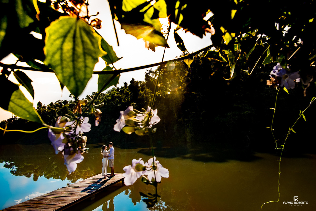 Casal abraçado entre as flores no lago do Recanto do Bosque durante Pre Wedding em Guaratinguetá.