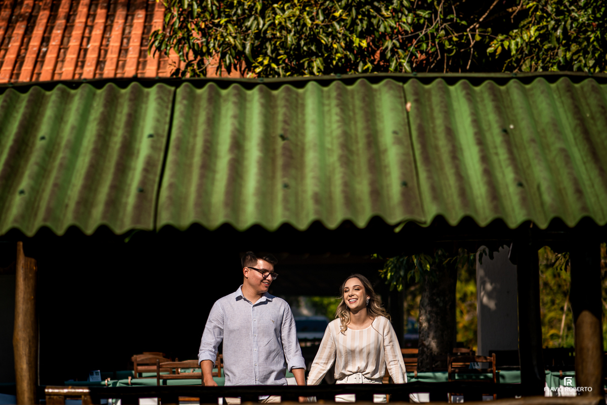 Casal de mãos dadas caminhando no pre wedding no restaurante Recanto do Bosque em Guaratinguetá.