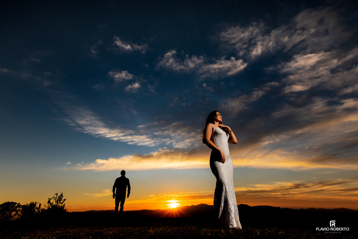 Casal de noivos caminhando no Pico Agudo em Santo Antônio do Pinhal durante o pôr do sol em Ensaio Pré Wedding.
