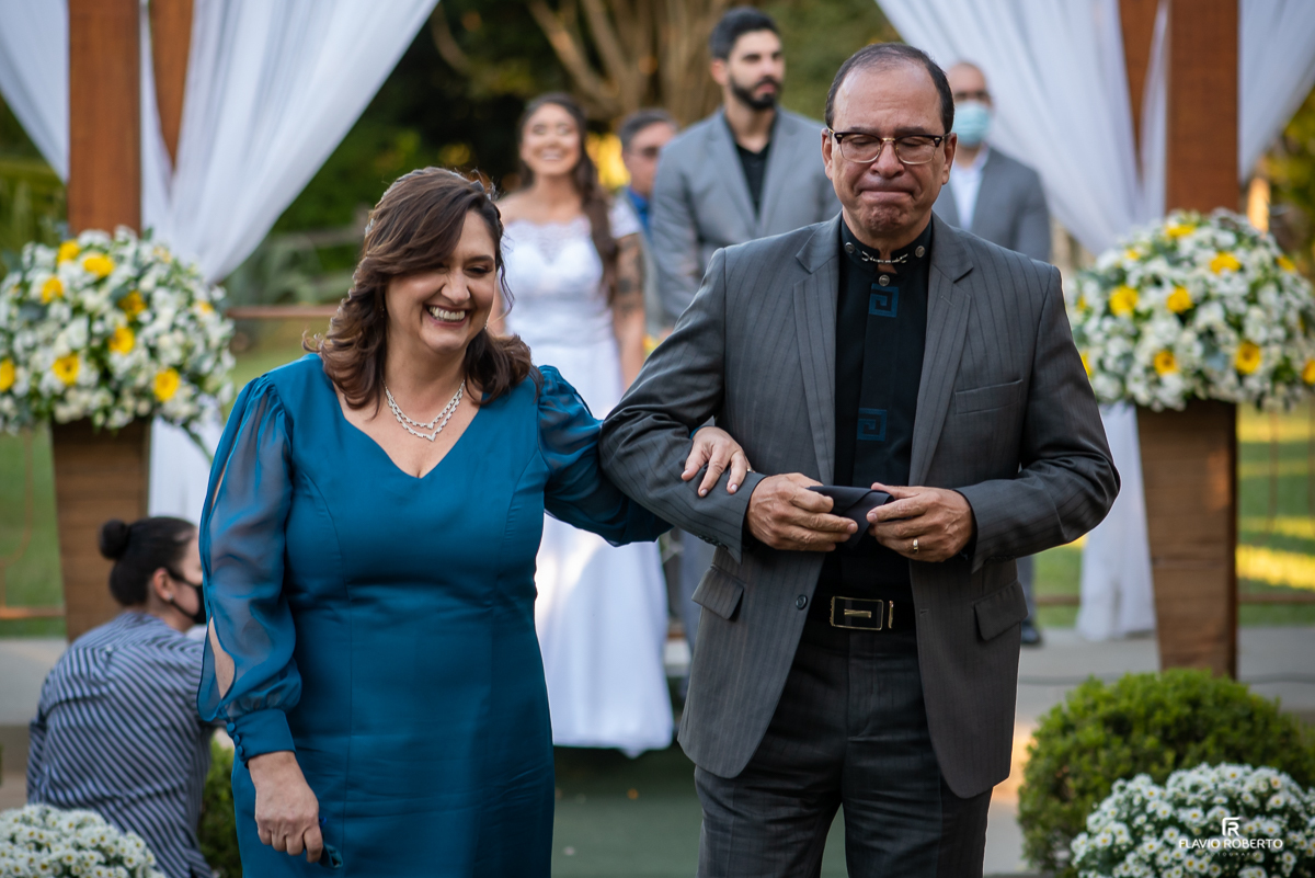 Pais da noiva saindo emocionados após cerimonia de casamento no Sítio dos Ipês
