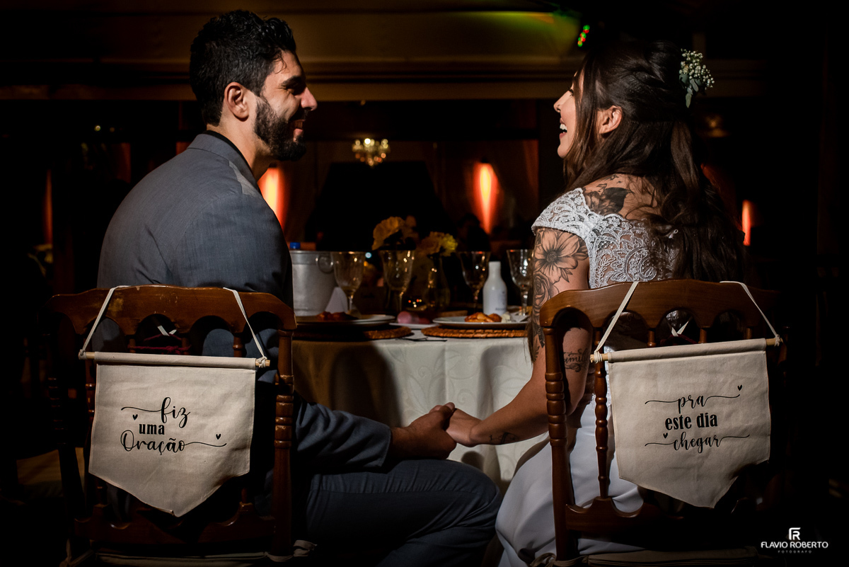 Noivos sentado na mesa jantando no final do casamento no Sítio dos Ipês em Taubaté
