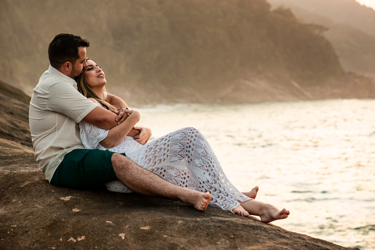 noivos sentados nas pedras olhando o mar durante ensaio pre wedding em Trindade, Paraty/RJ