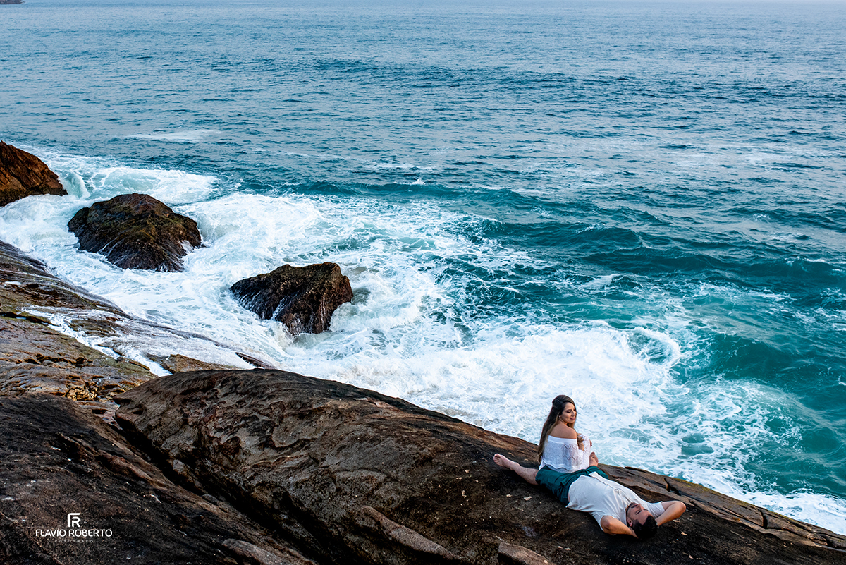 casal deitado nas pedras na praia do cepilho durante ensaio pre wedding em Trindade, Paraty/RJ