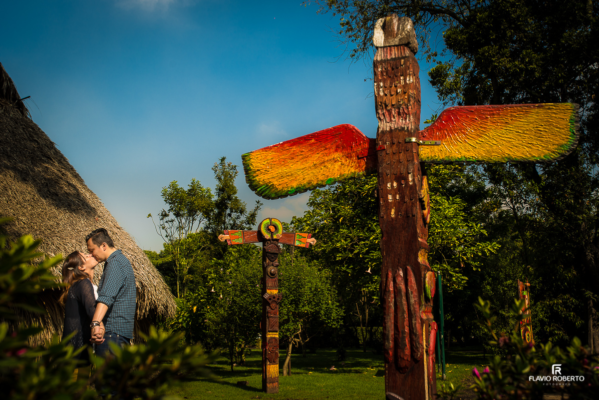 casal se beijando perto dos tótem dos índios
