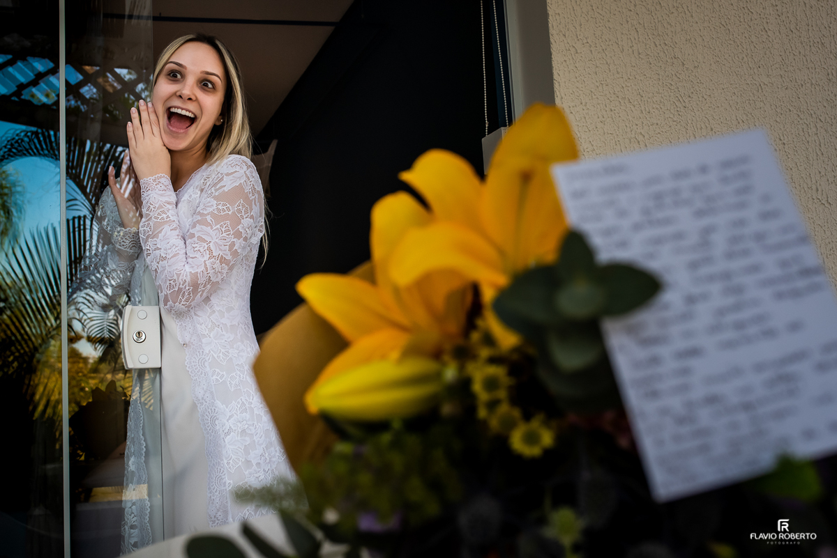 Noiva sorrindo ao ler a cartinha do noivo no making off no club dos 500 em Guaratinguetá
