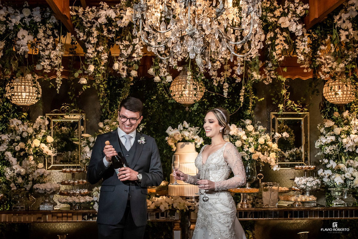 Noivos estourando a champagne em Casamento realizado no Recanto do Bosque em Guaratingueta