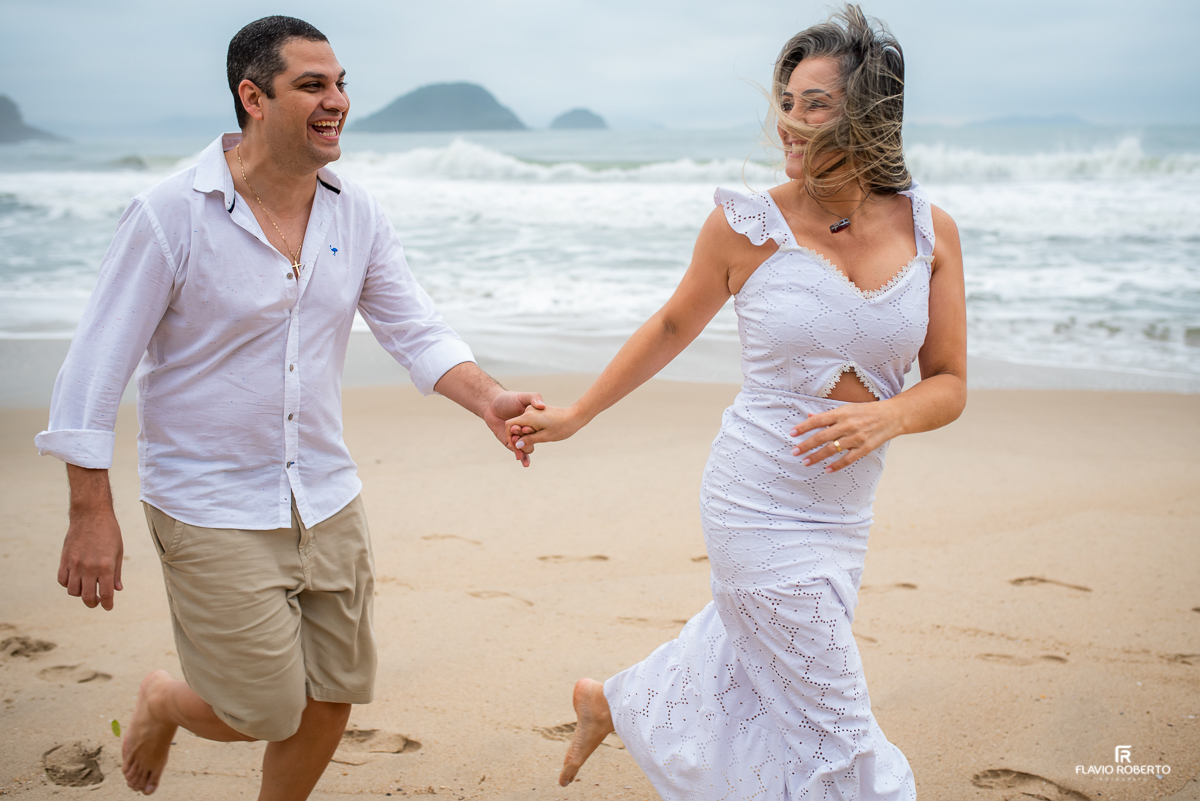 Casal correndo pela areia da Praia do Félix durante Ensaio Pre Wedding em Ubatuba