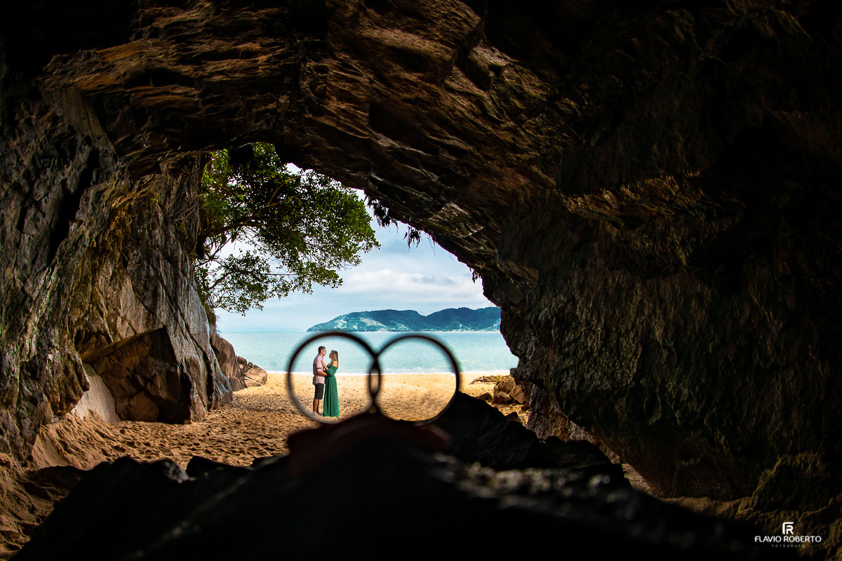 casal abraçado dentro de suas alianças na Gruta que Chora, na Praia da Sununga durante ensaio pre wedding em ubatuba