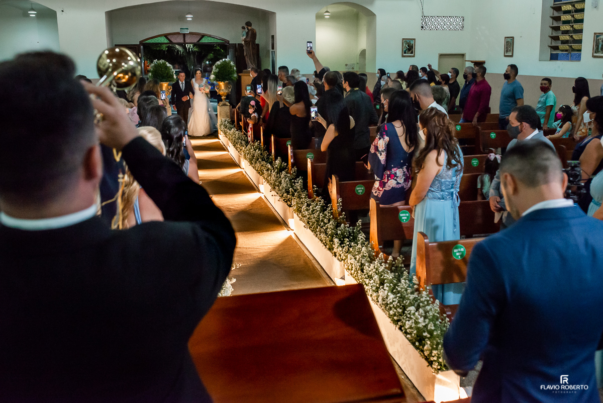 Noivo emocionado ao som dos trompetes olhando a noiva entrar em Casamento na Paróquia Santana em Roseira