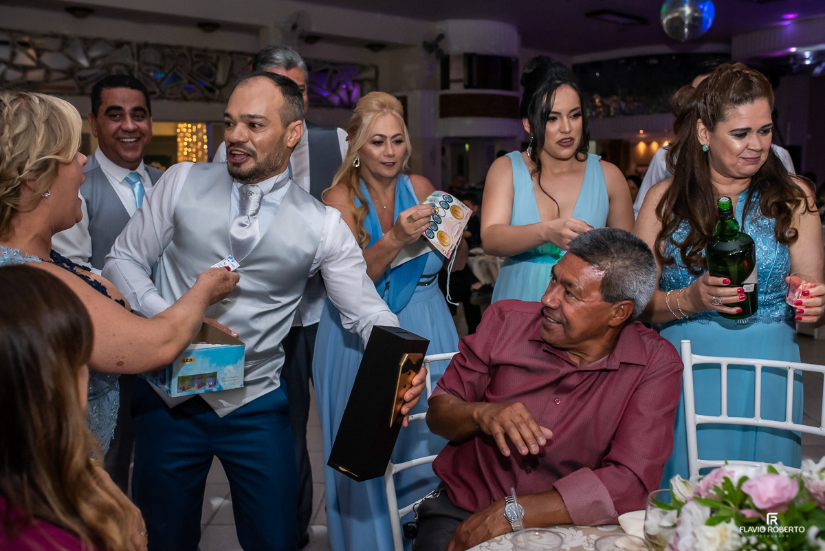 Noivos passando a gravata e o sapatinho entre os convidados durante casamento no espaço vip de Guaratingueta-sp