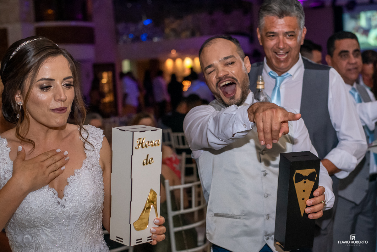 Noivos passando a gravata e o sapatinho entre os convidados durante casamento no espaço vip de Guaratingueta-sp