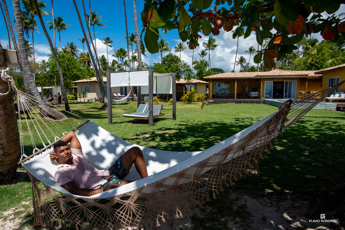 Noivo deitado na rede em frente ao mar no Orixás Residences do Hotel Vila dos Orixás antes do casamento em Morro de Sao Paulo na Bahia 