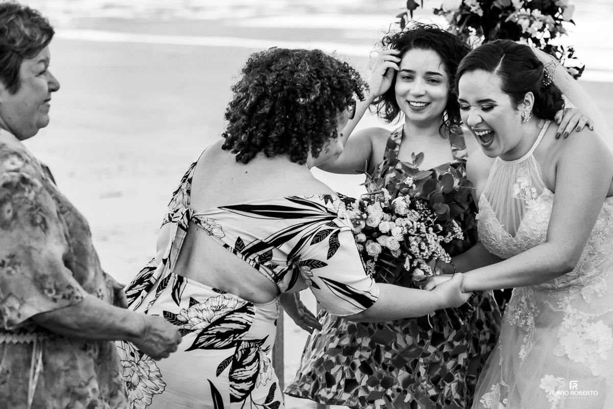 convidados abraçando a noiva na praia depois do Casamento no Hotel Vila dos Orixás em Morro de Sao Paulo na Bahia 