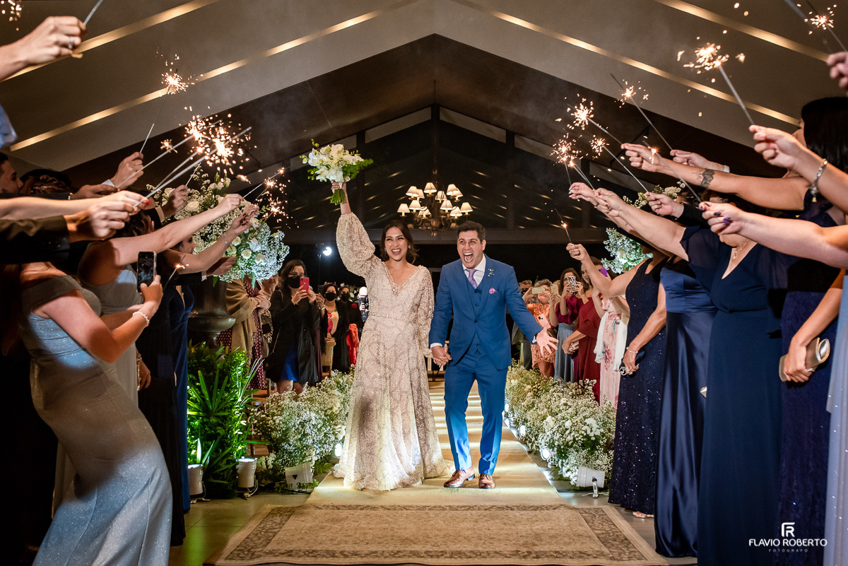 noivos saindo da Igreja celebrando após o término da Cerimônia na Capela do Recanto do Bosque em Casamento em Guaratingueta 