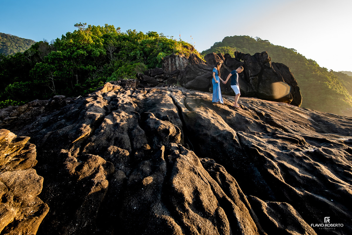 Noivos caminhando pelas pedras da Praia do Cepilho, em Pre Wedding realizado em Trindade-Paraty