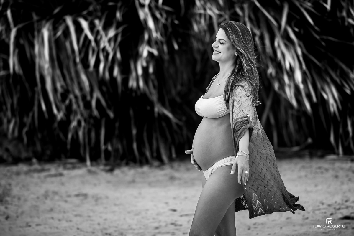 Mulher grávida sorrindo durante ensaio de gestante na praia de Ubatuba 