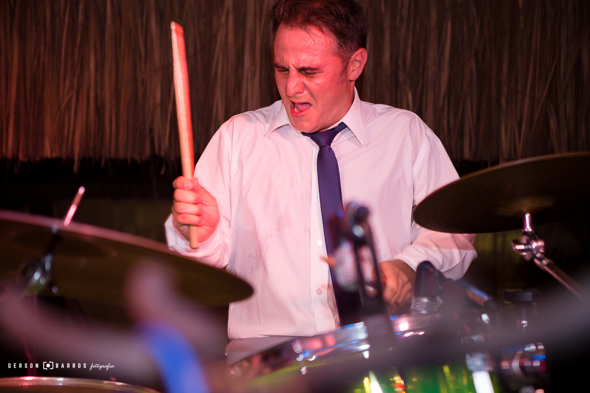 noivo tocando bateria no seu casamento na praia interior rj buzios geriba fotografo de casamento