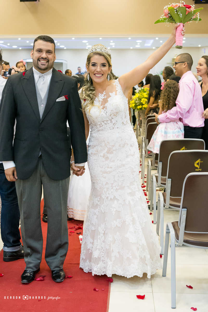 noiva feliz com noivo levantando o buquet