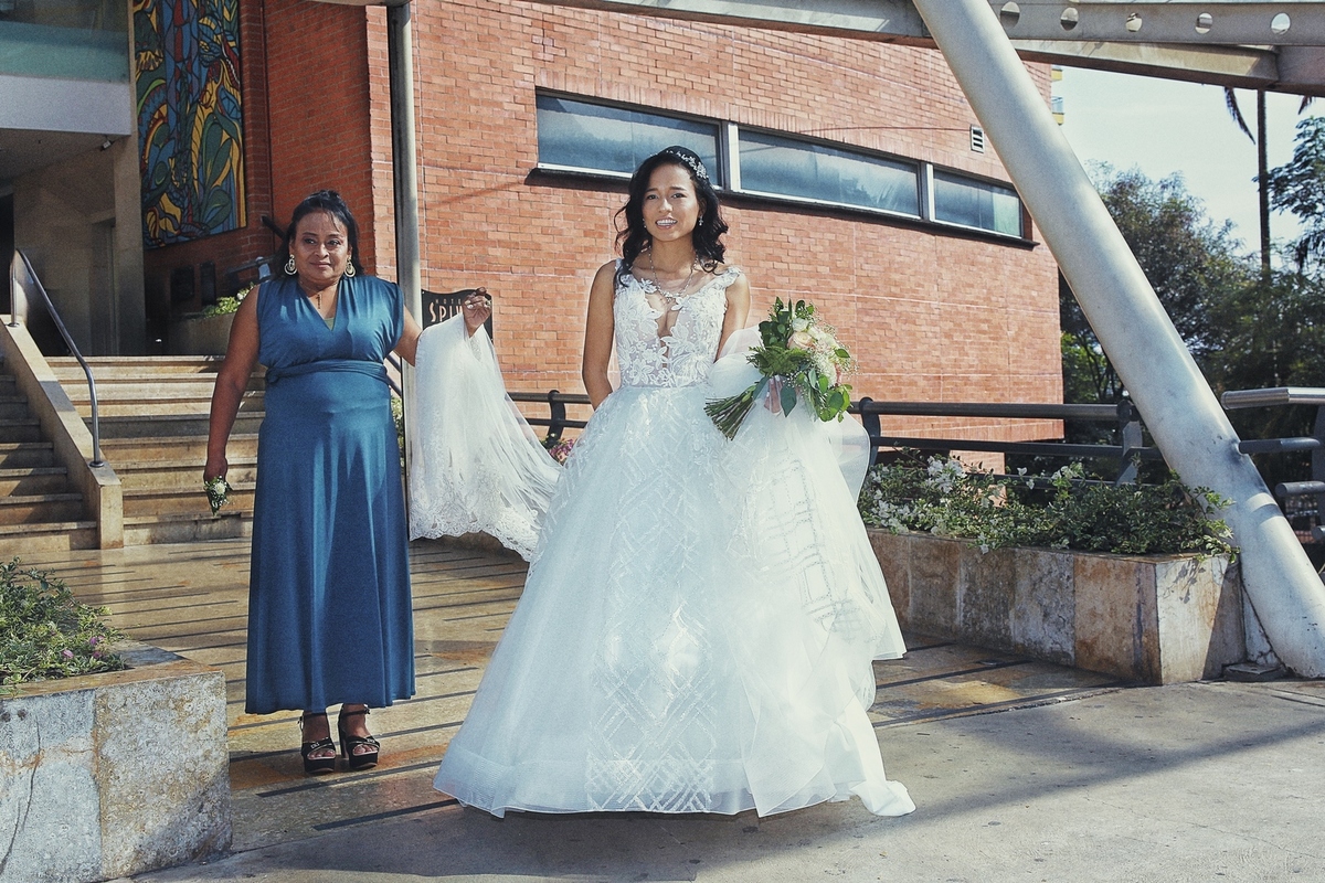 La novia saliendo hacia la iglesia y el fotógrafo Manuel Espitia captando el momento cámara en mano.