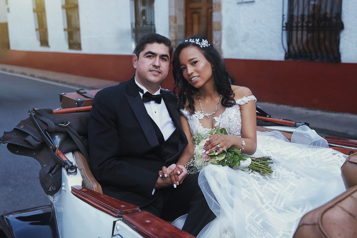 Fotografía de los recién casados en su primer paseo con carro clásico.