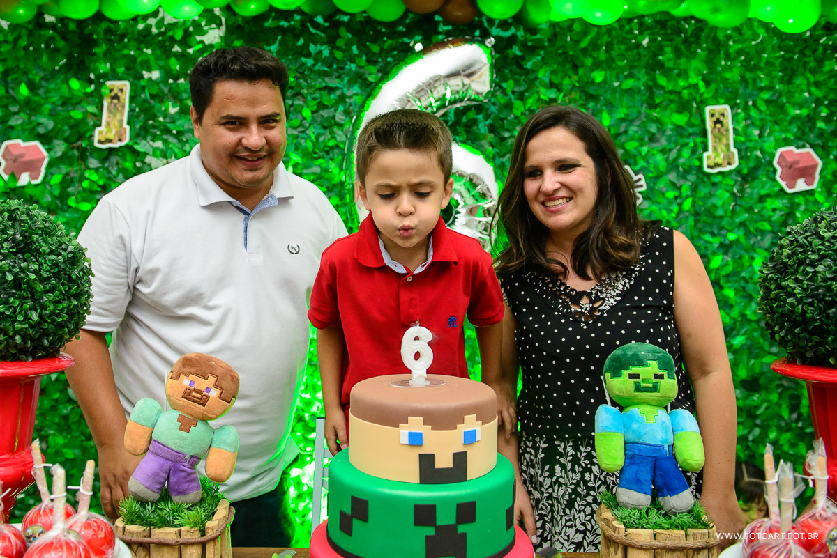 Assoprando a vela na hora do parabens atras do bolo do minecraft no Espaço Kids Buffet Infantil