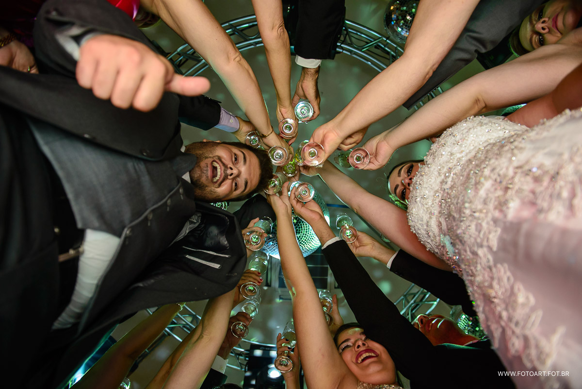 foto de baixo para cima do brinde dos noivos com padrinhos  no luz tropical eventos foto de Anderson Silva Fotoart fotografo sp
