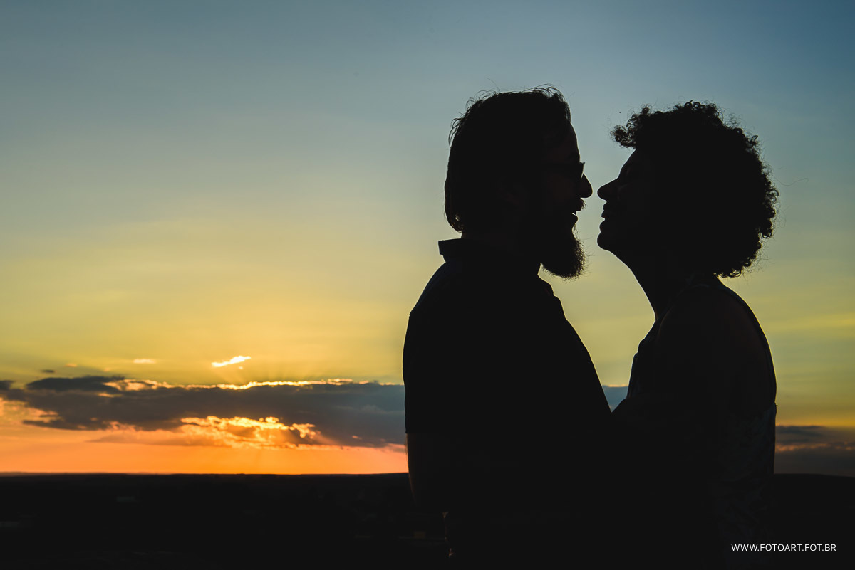 lindo por do sol com silhueta de do casal amanda e carlos na igreja de rubiao junior para o fotografo de casamento de Botucatu sao paulo e regiao Anderson Silva Fotoart