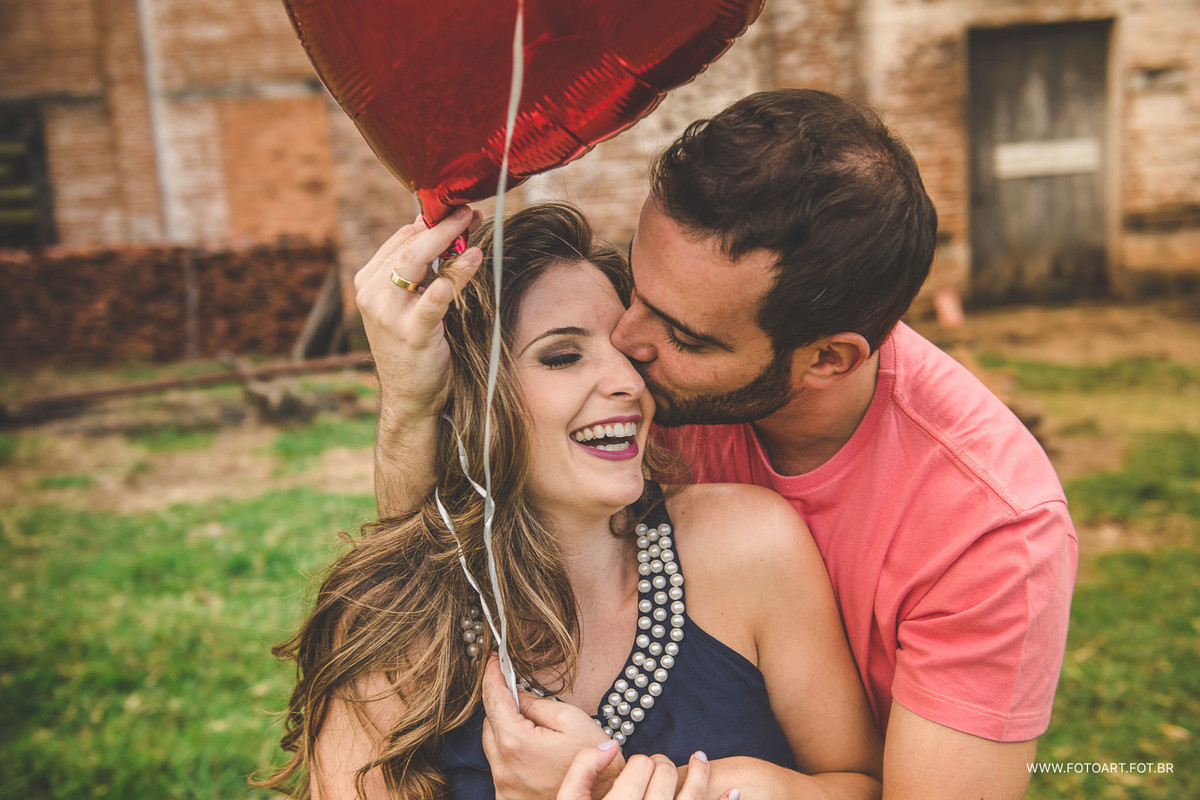 Noivo dando um beijo no olho da noiva com baloes vermelhos em frente a usina indiana botucatu por Anderson Silva Fotoart fotografo sp