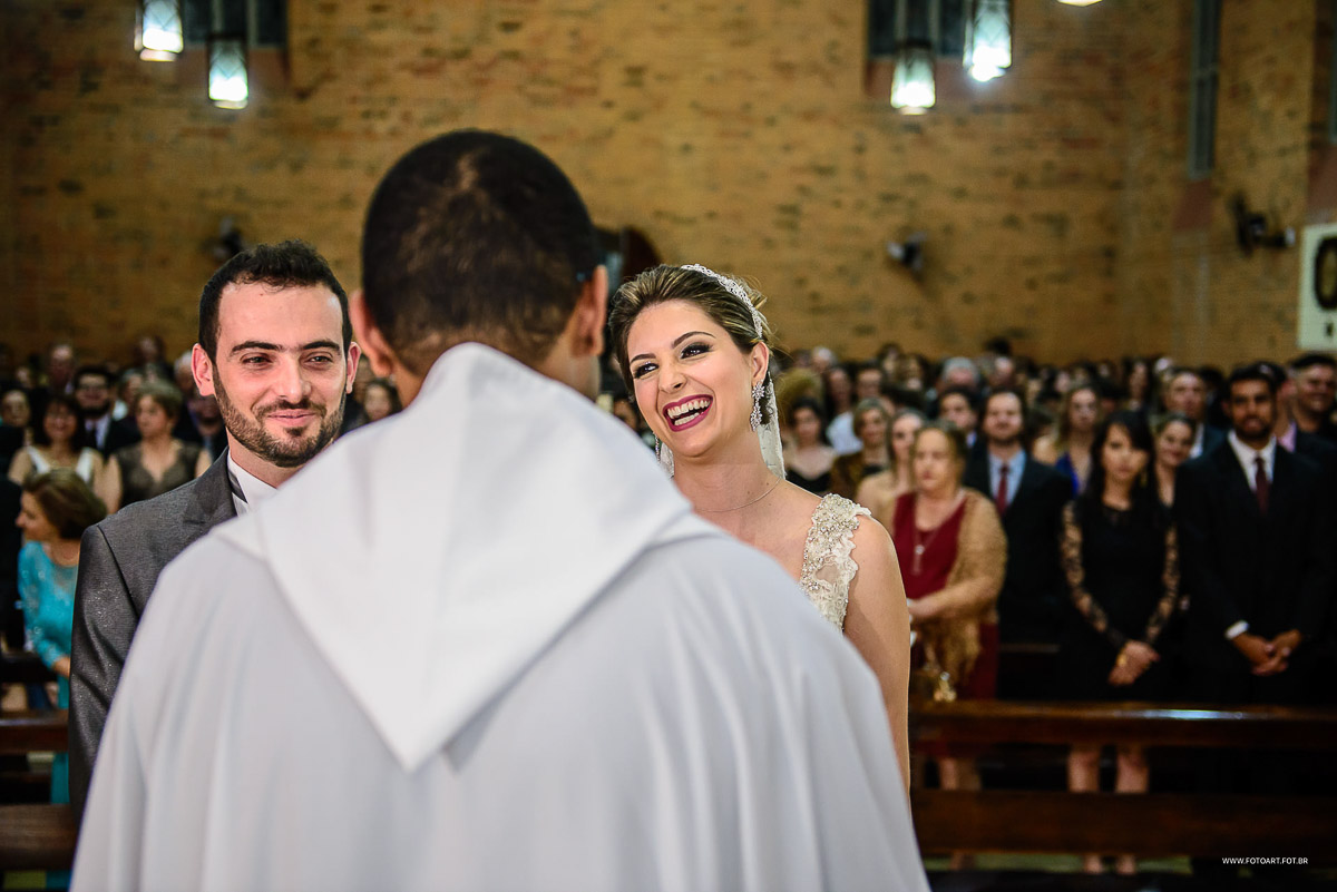 Noivos ouvindo homilia do padre Gustavo Viaro Correa e sorindentes na capela do Seminário Arquidiocesano São José  Botucatu por Anderson Silva Fotoart fotografo sp