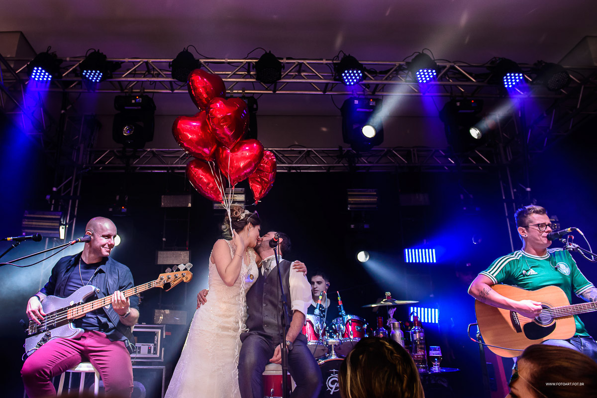 Noivos se beijando com bexigas de coracao e gas helio no palco no buffet Luz Tropical Festas e Eventos Botucatu por Anderson Silva Fotoart fotografo sp