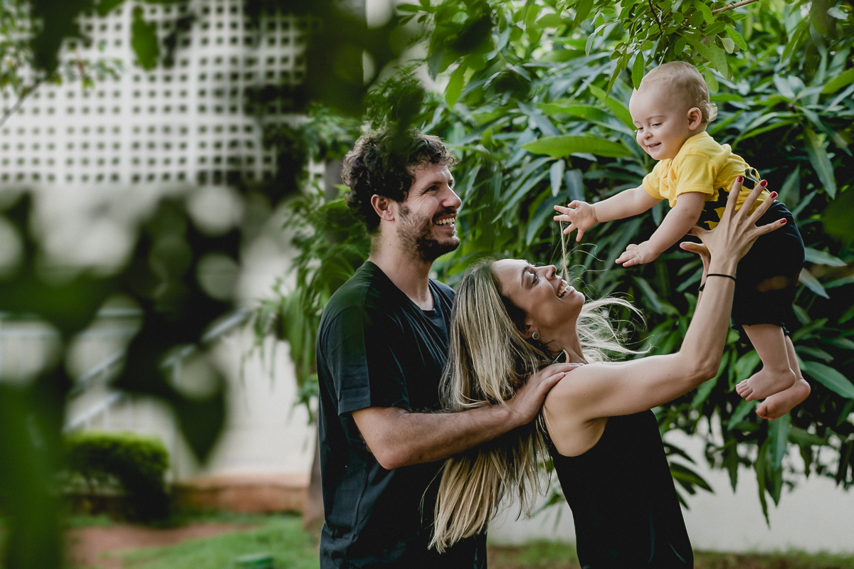 brincando de aviaozinho com o papai e a mamae no ensaio familia