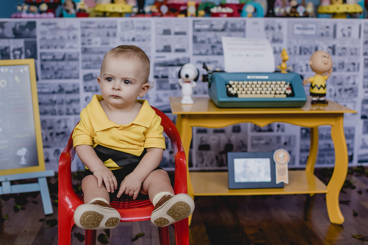 joao sentando na frente da mesa do bolo