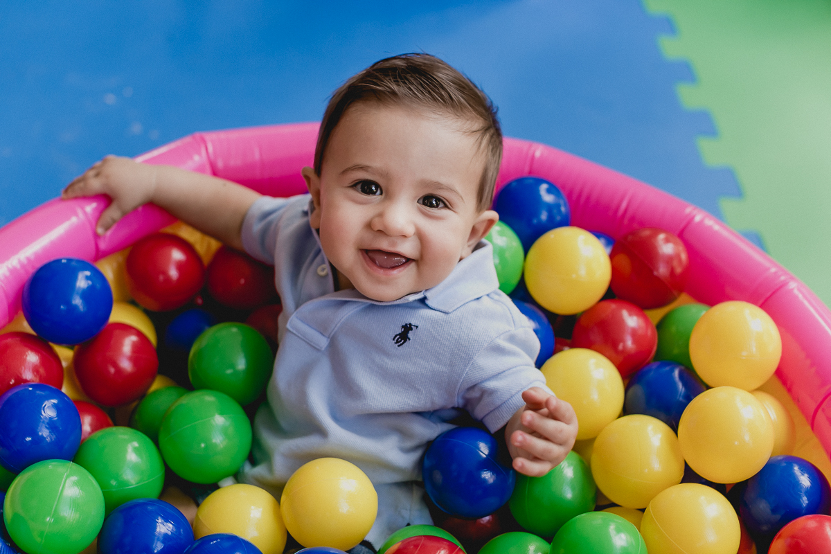 amiguinho sorrindo muito na piscina de bolinhas