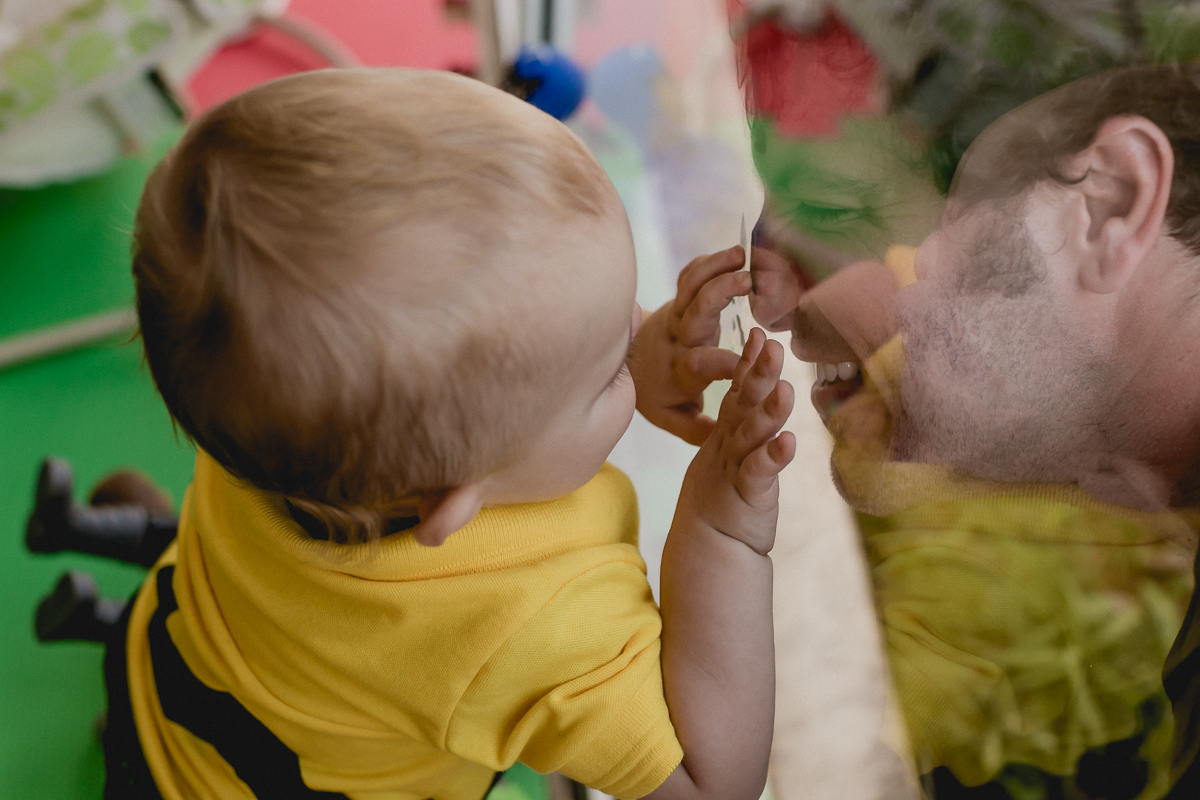 pai e filho brincando através do espelho