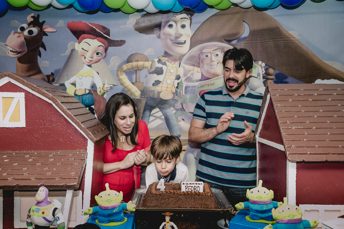 Pedro e familia assoprando a vela na hora do parabens