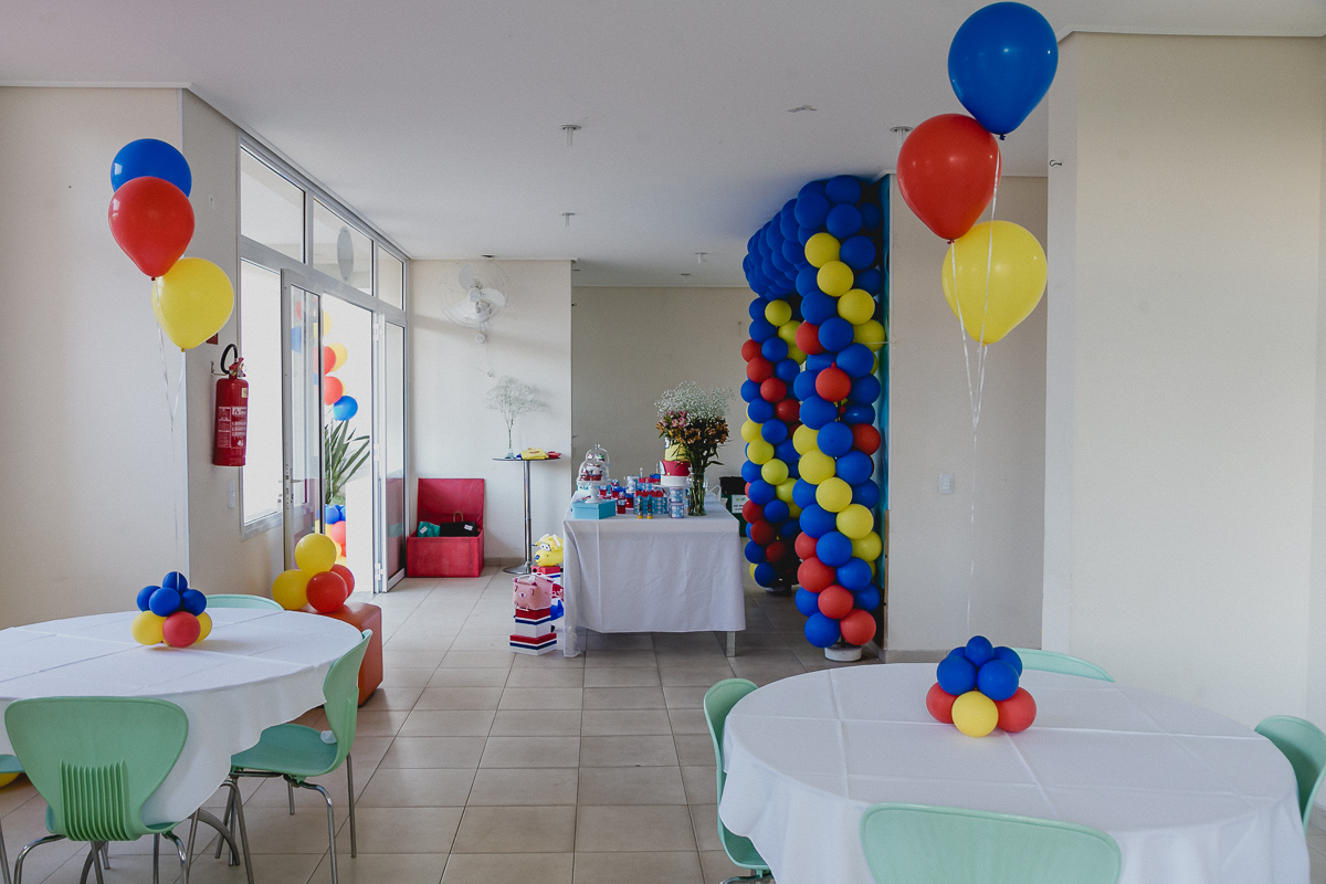 interior do salao de festas do condominio e mesa com o tema avioes