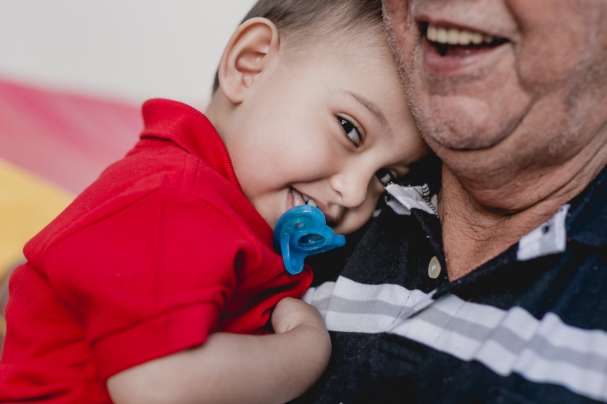 pedro dando risada no colo do avô