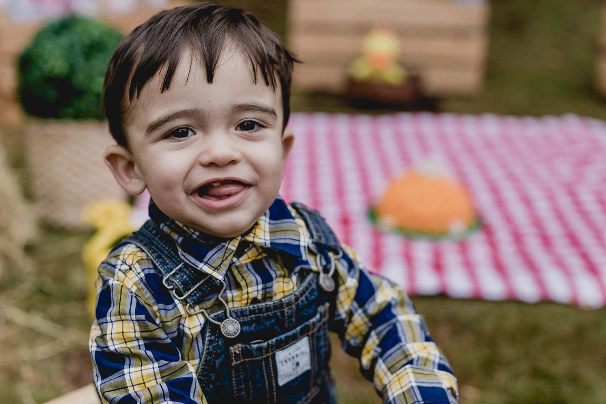 sorrindo na frente do bolo