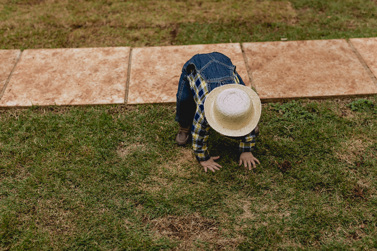 de chapeu agachando no chão
