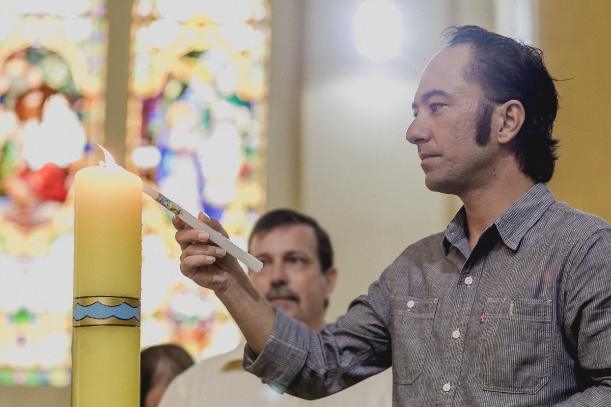 padrinho acendendo a vela do batizado
