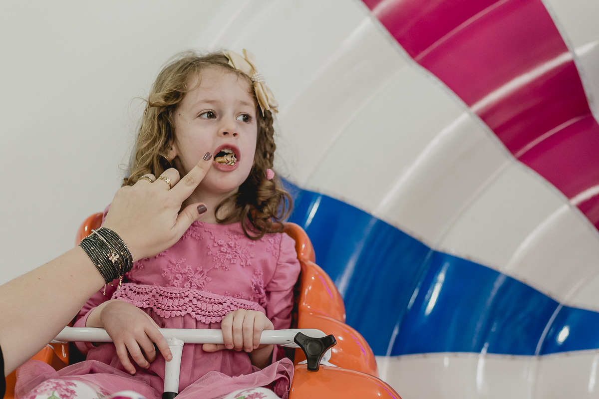 sofia comendo salgadinho enquanto brinca na roda gigante