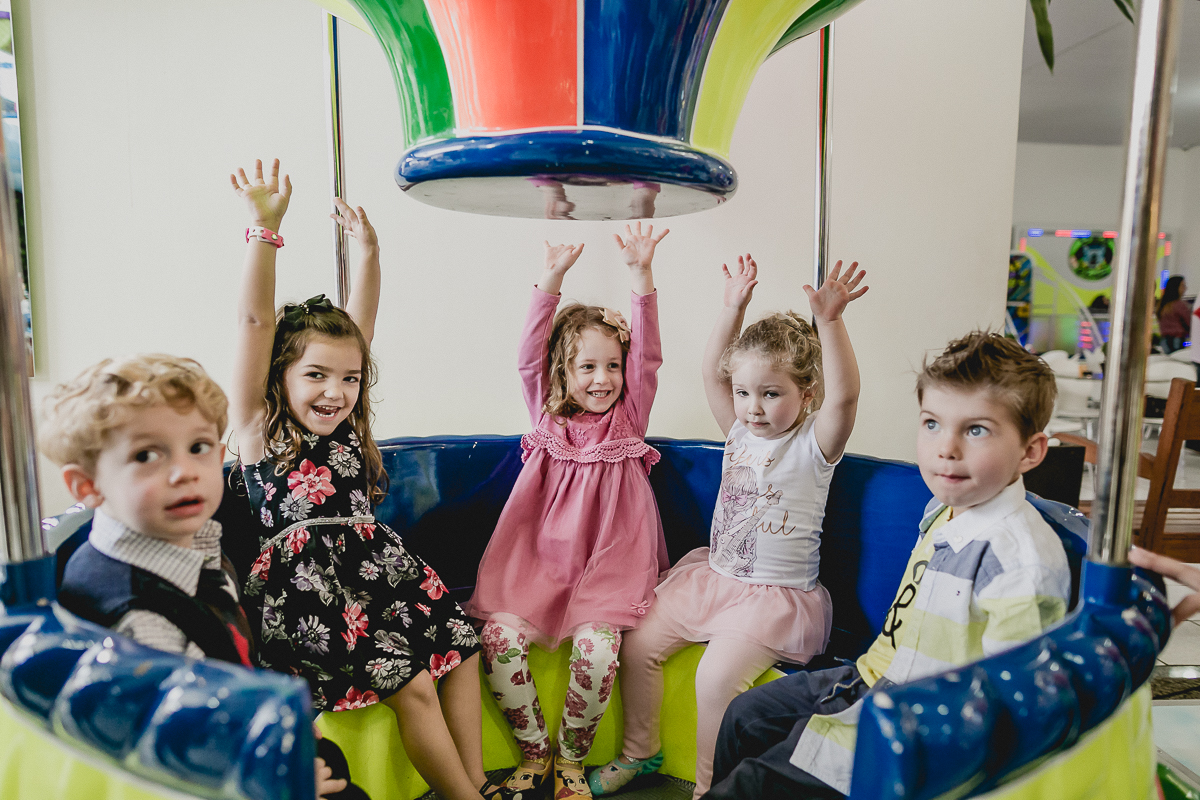 criancas com a mao para cima no balao